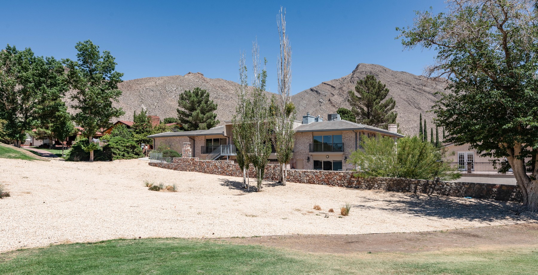 Rear exterior of 1013 Singing Hills with the Franklin Mountains rising behind the home