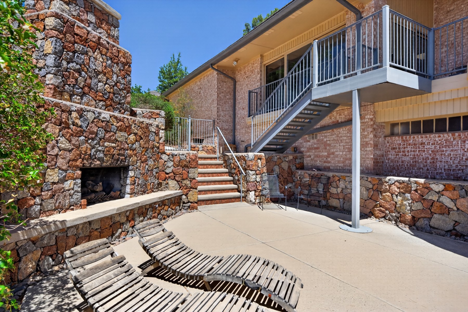 Stone outdoor terrace and fireplace at 1013 Singing Hills